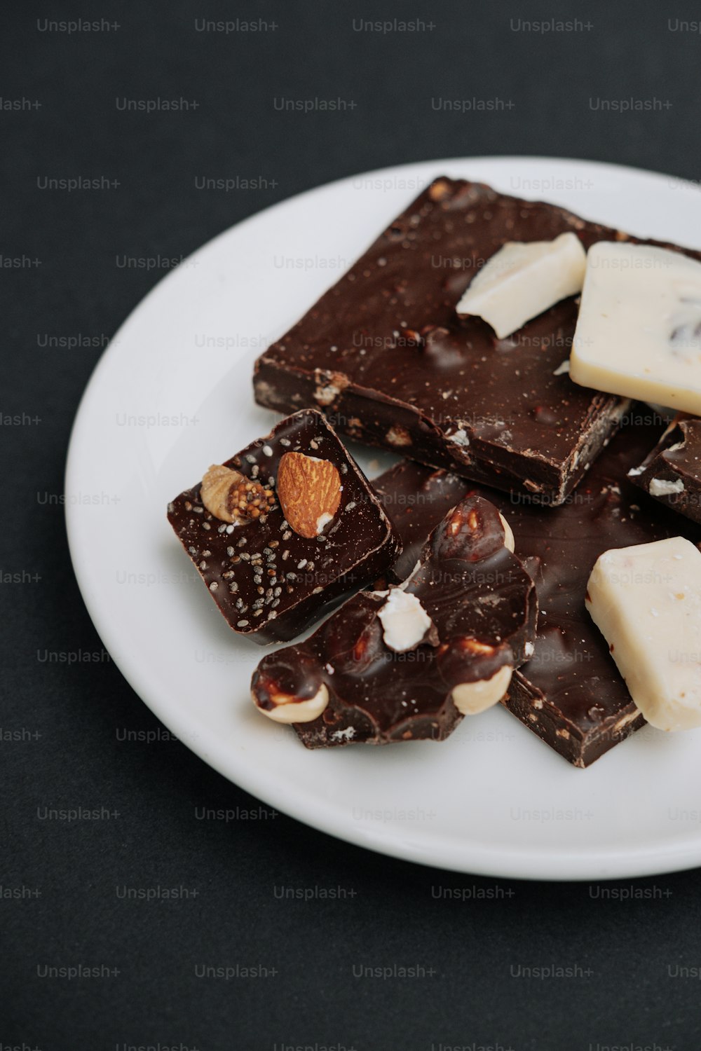 a white plate topped with pieces of chocolate and nuts