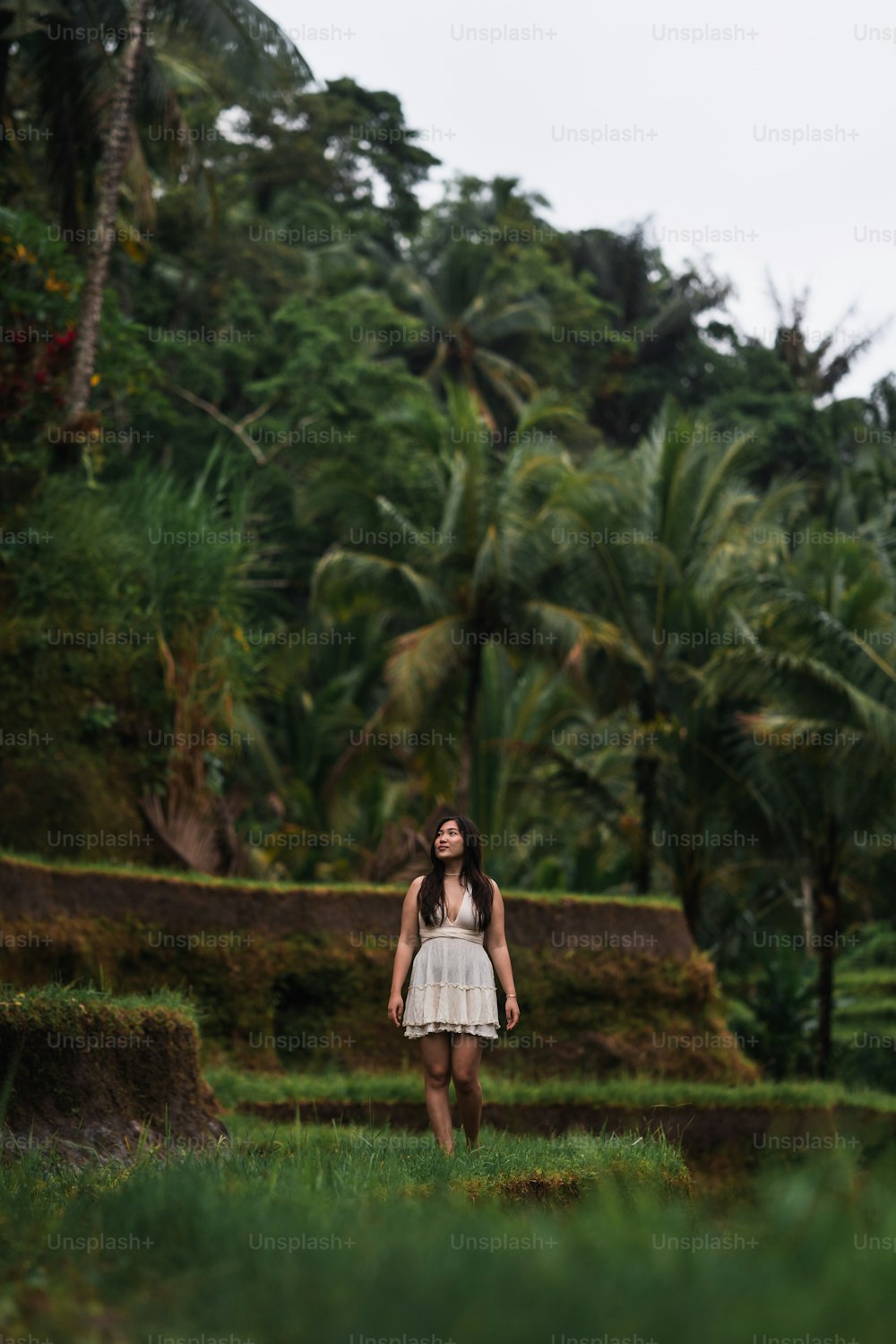 a woman in a white dress standing in a field