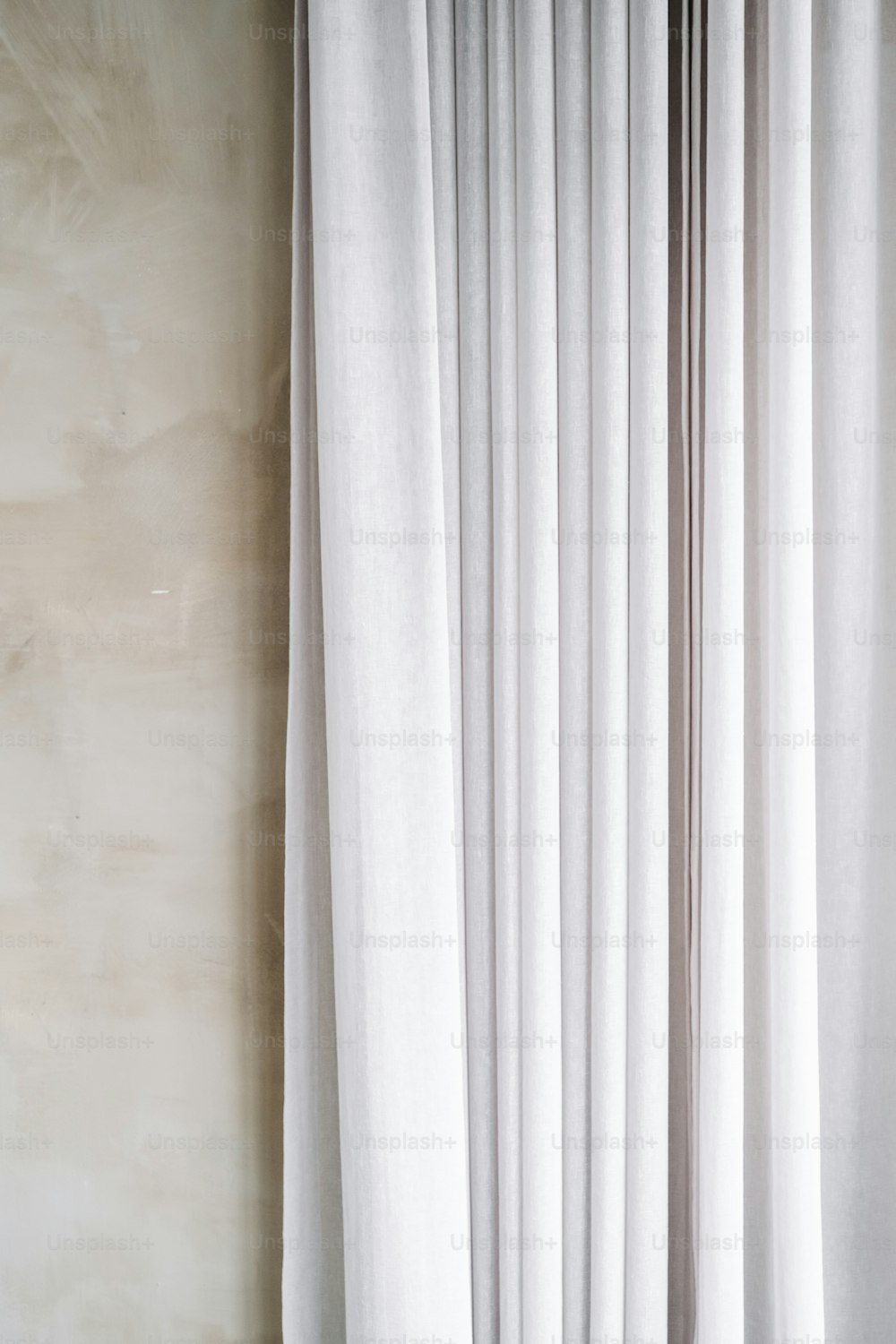 uma cortina branca pendurada no lado de uma parede
