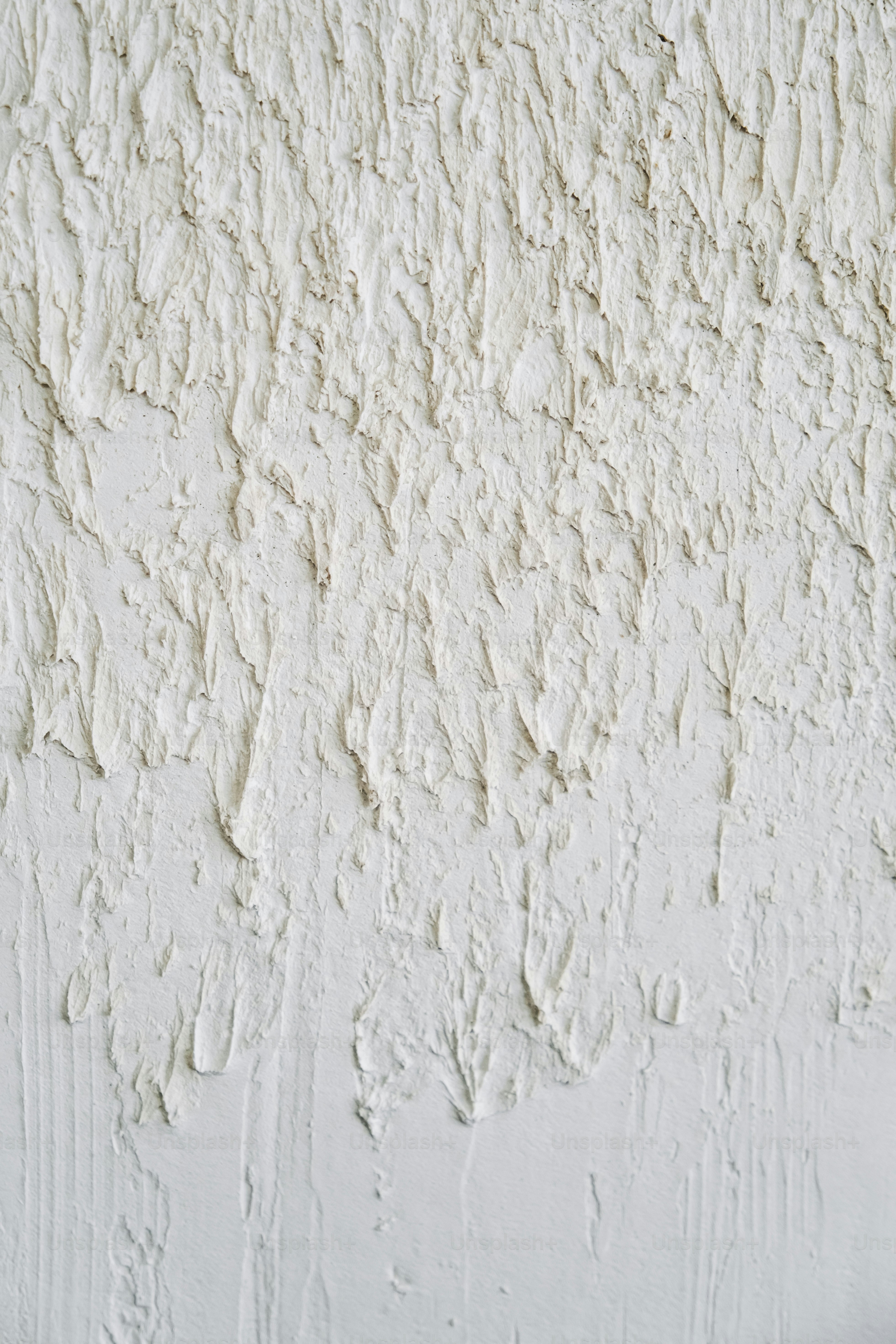 a close up of a wall with white paint
