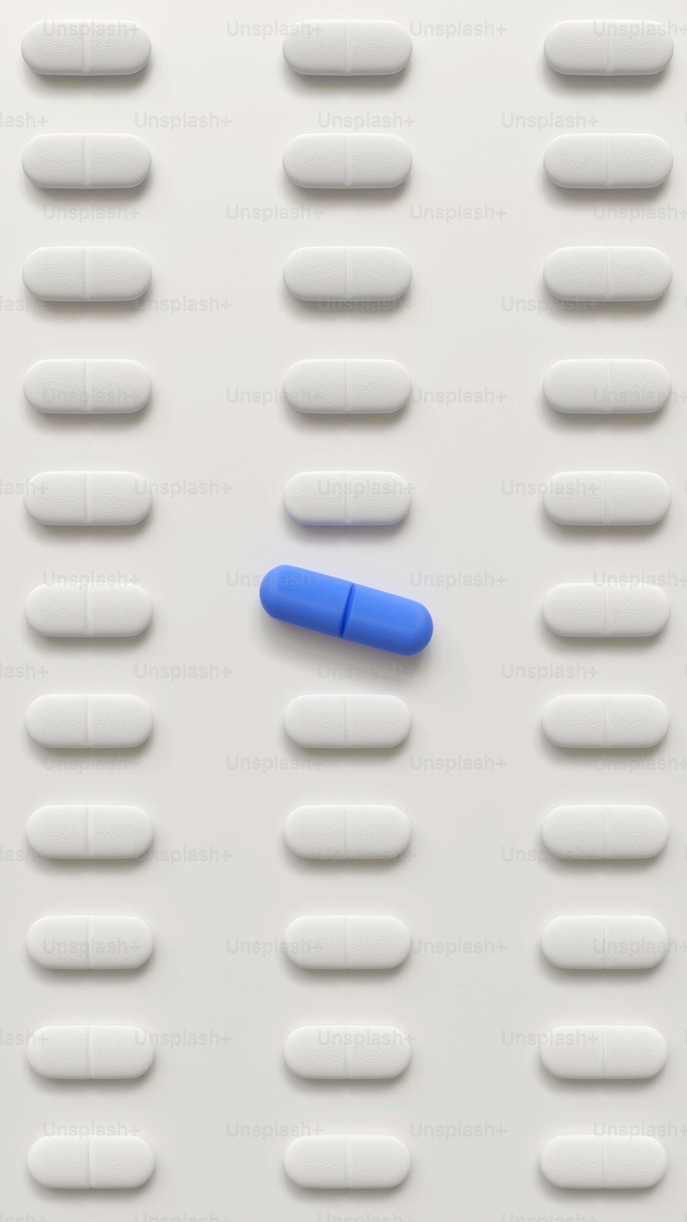a blue pill laying on top of a white surface