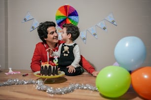 Eine Frau und ein Kind sitzen an einem Tisch mit einem Kuchen