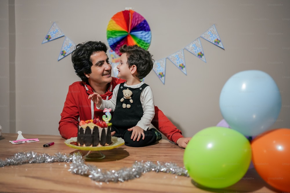 Una mujer y un niño sentados en una mesa con un pastel