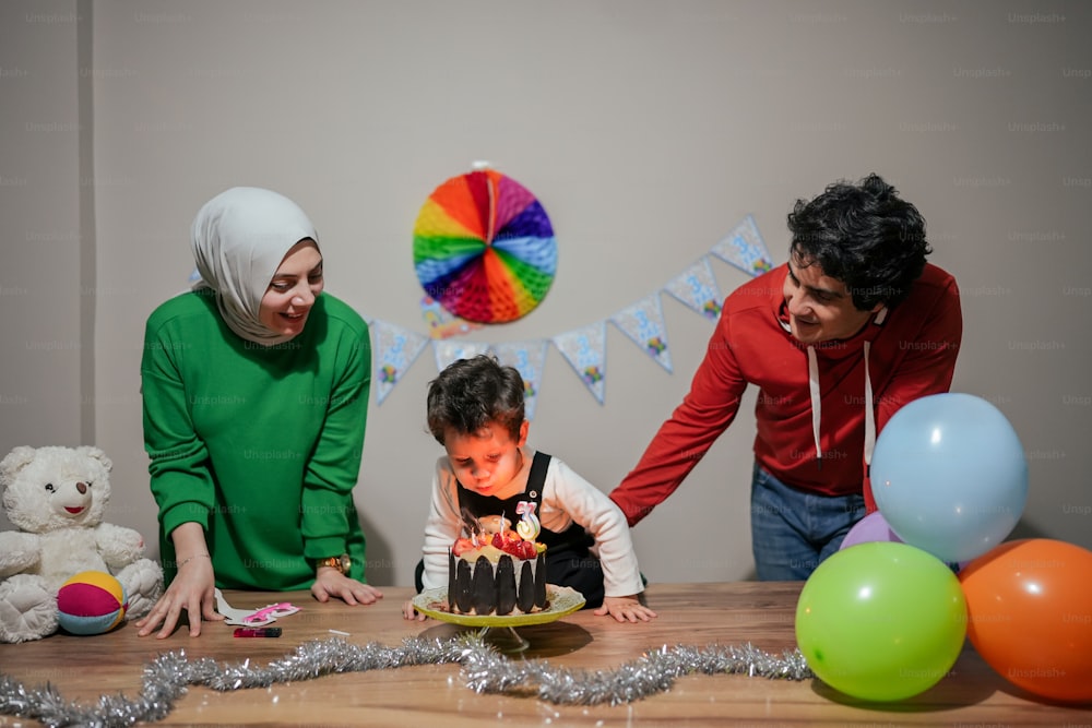 a woman and two children blowing out candles on a cake