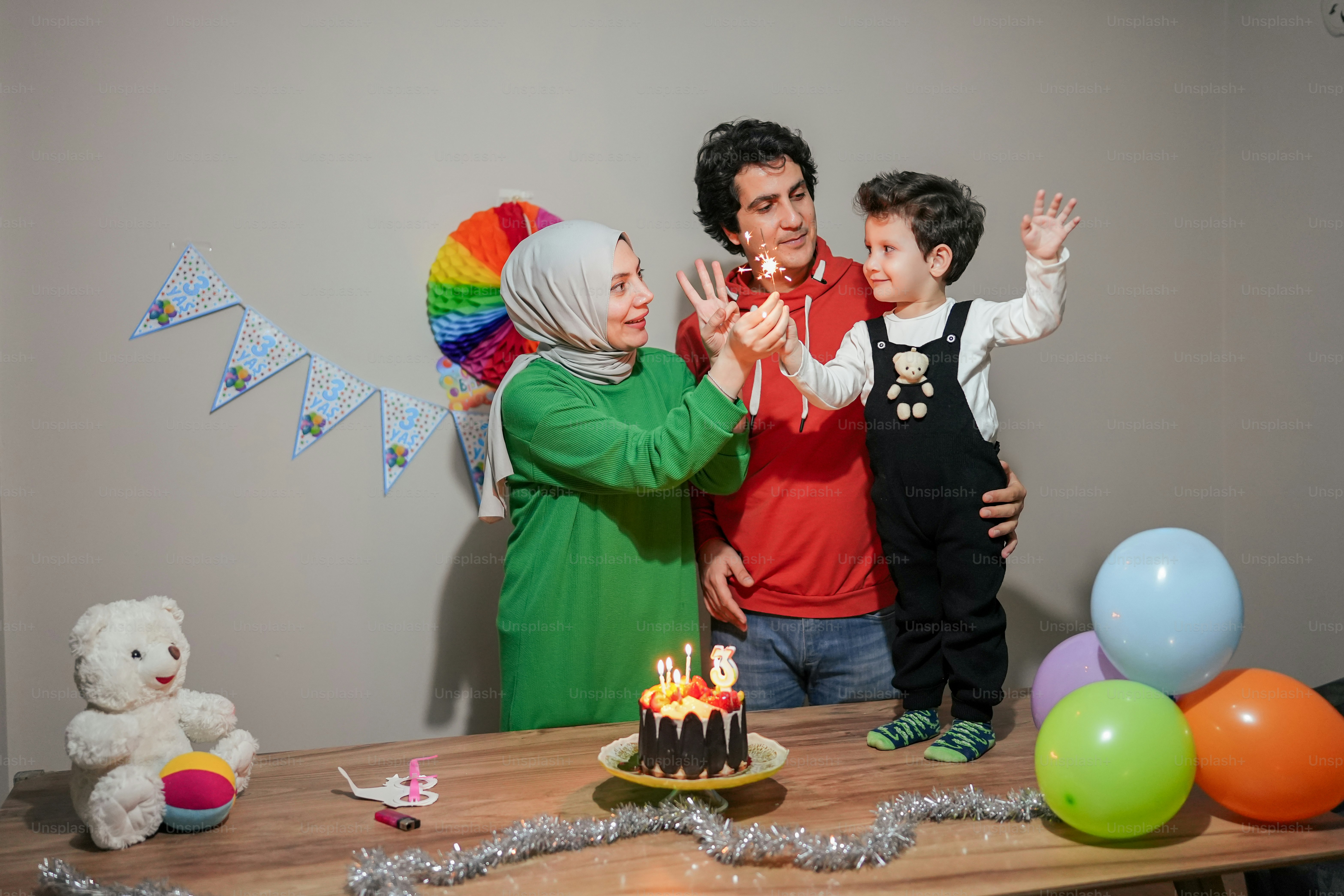 A group of people standing around a table with a cake photo – People ...