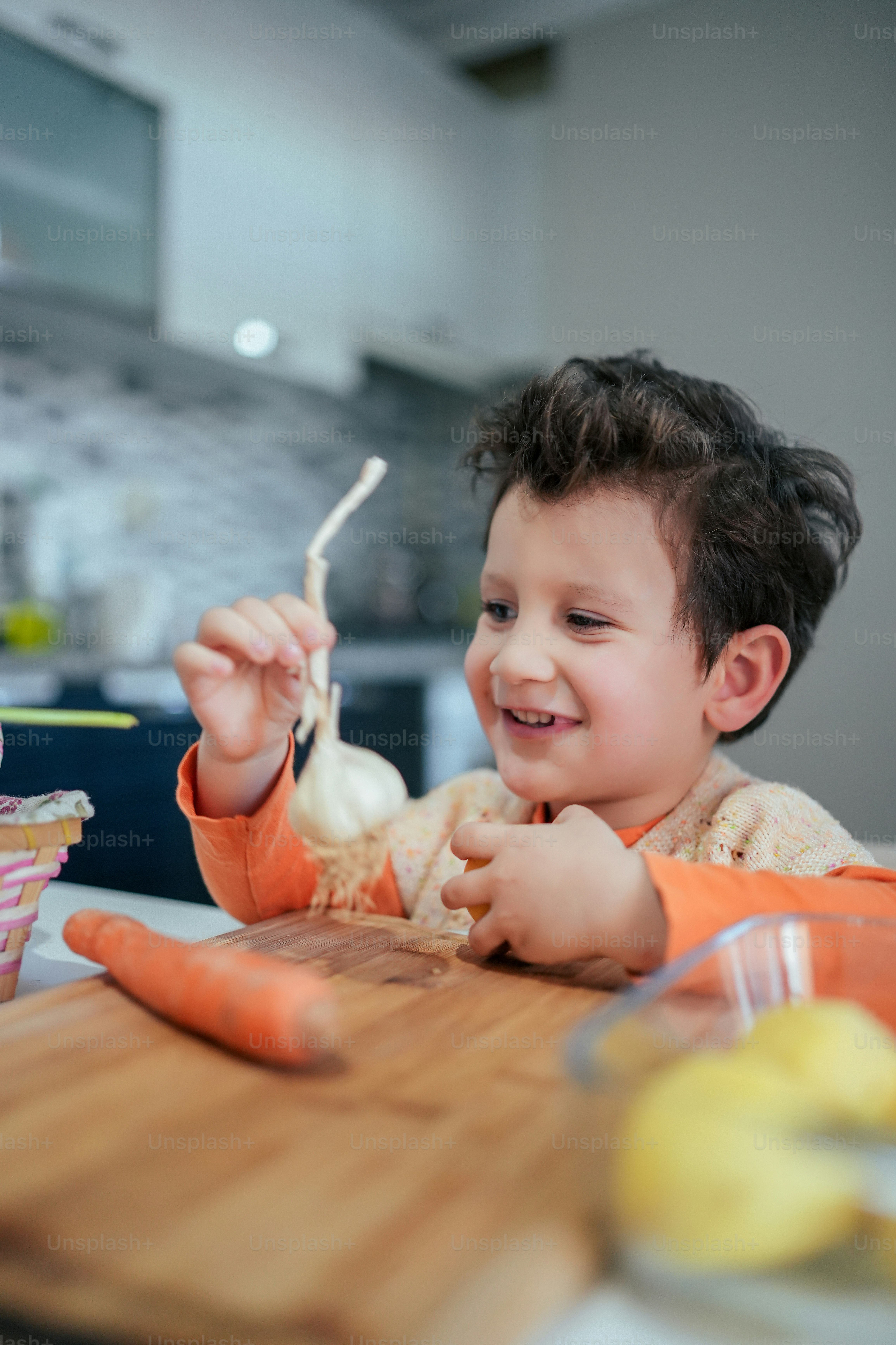 a little boy sitting at a table eating some food