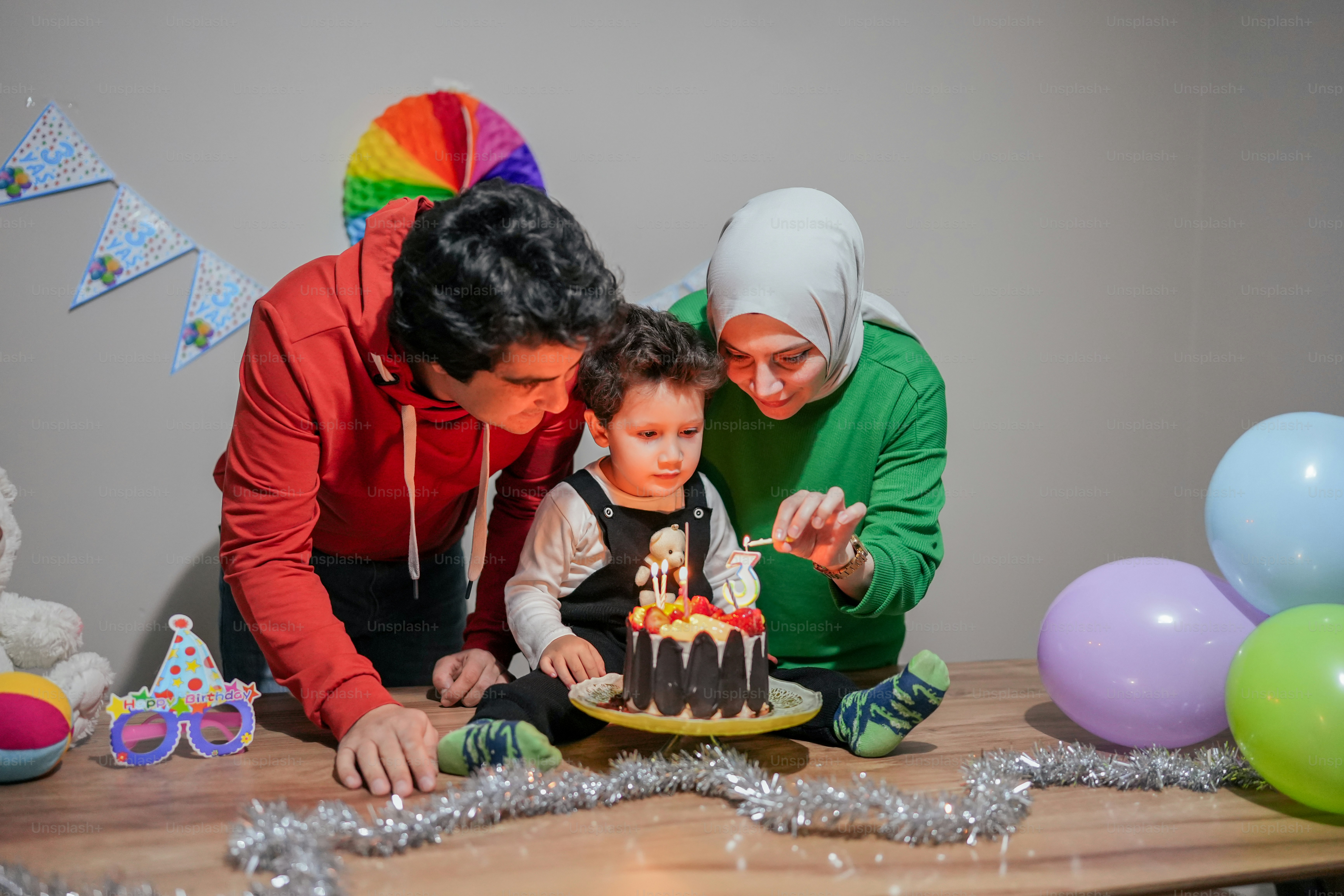 a woman and a child are blowing out the candles on a cake