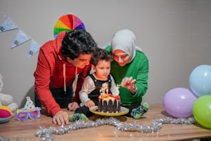 a woman and a child are blowing out the candles on a cake