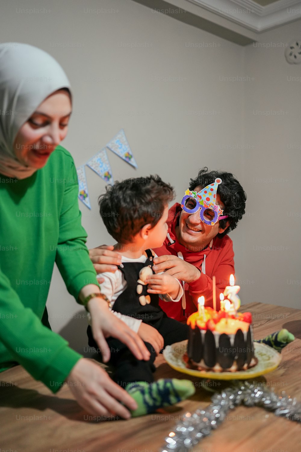 uma família comemorando um aniversário com um bolo