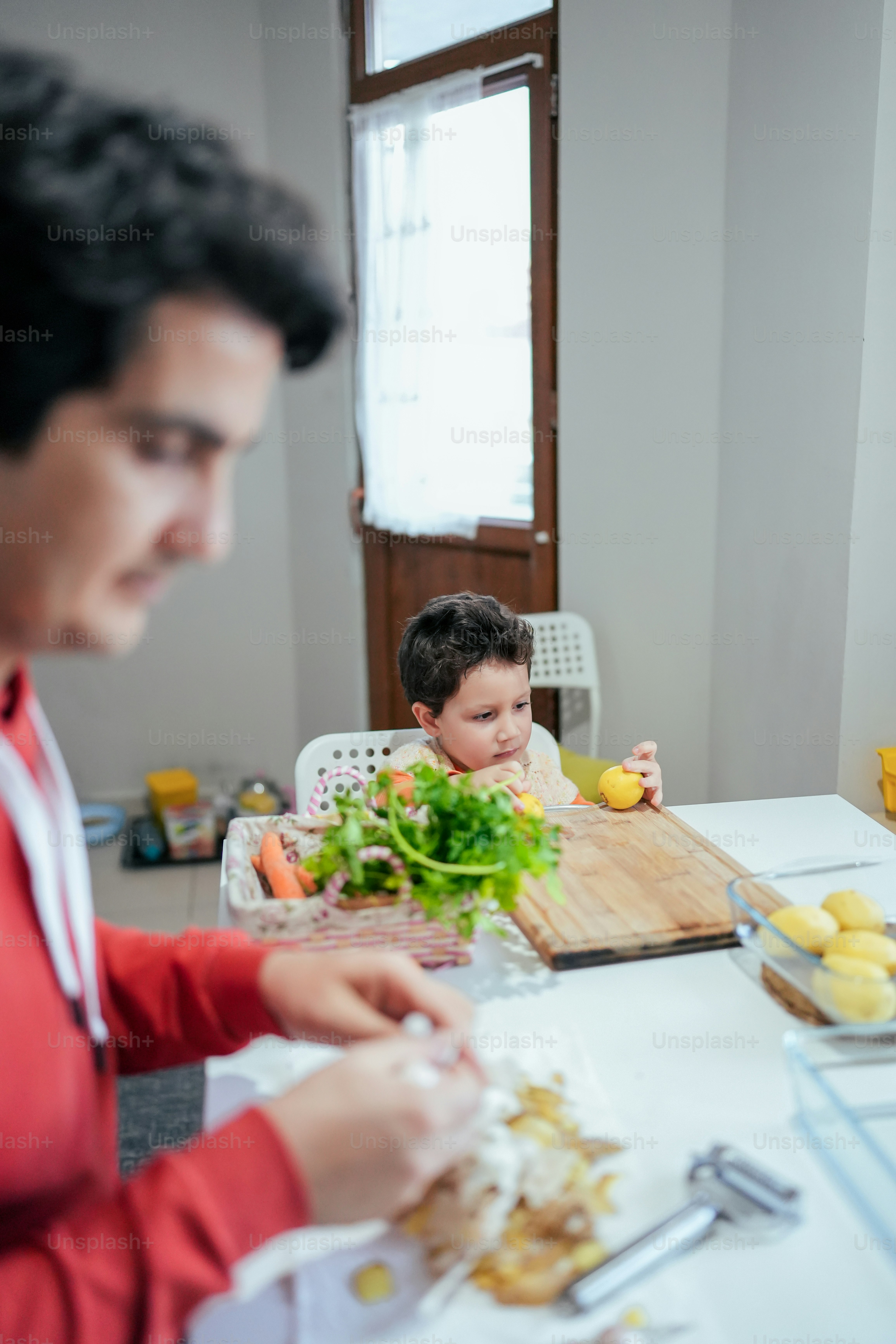 Un uomo e un bambino seduti a un tavolo con cibo