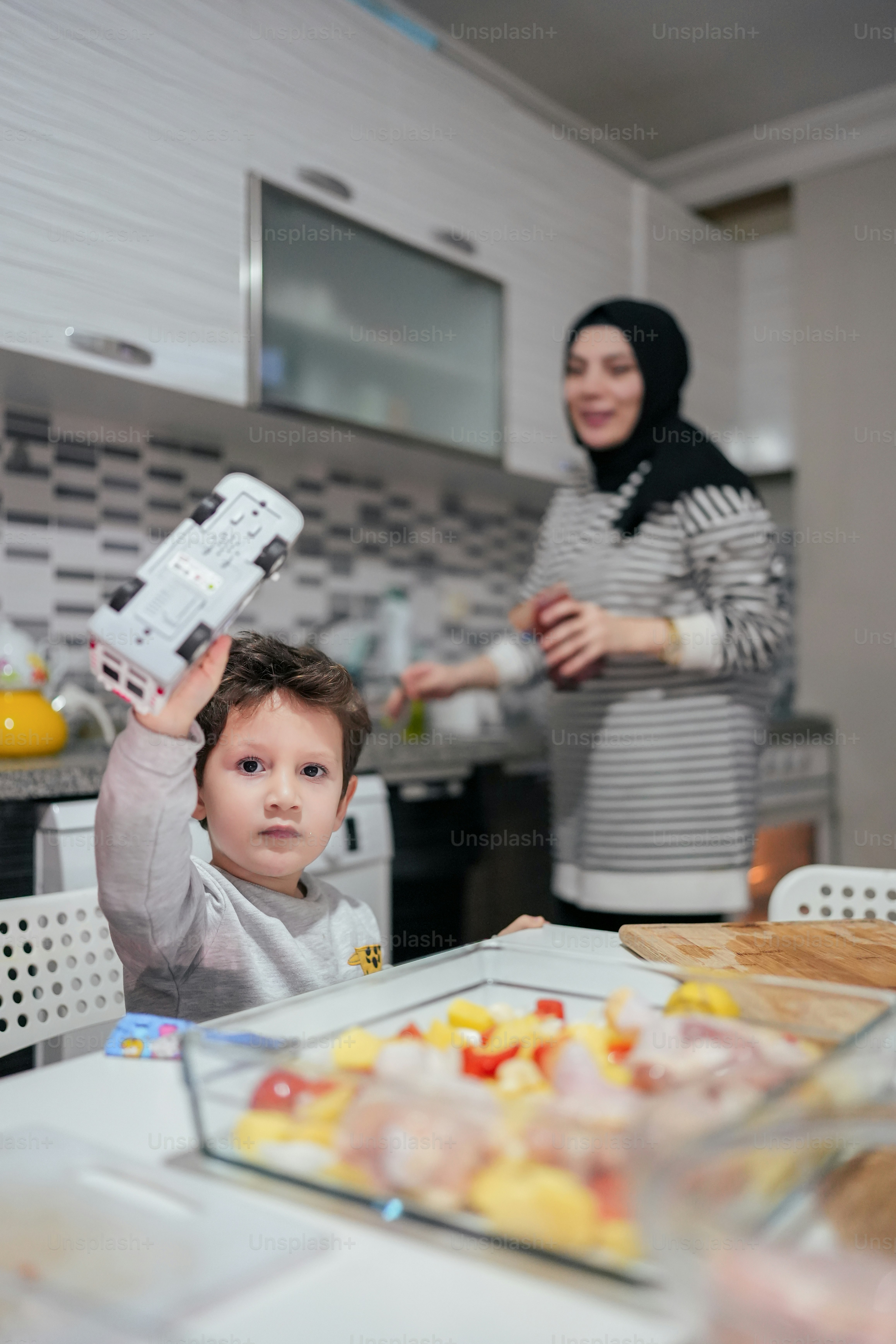 a woman holding a cell phone up to a child