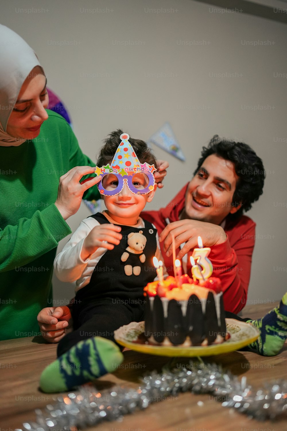 a man and a little girl sitting in front of a birthday cake