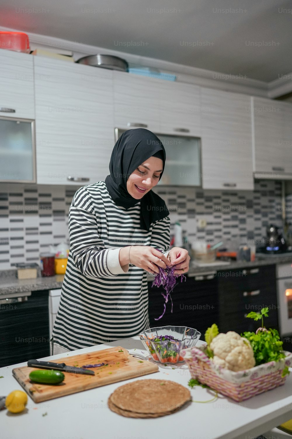uma mulher em pé em uma cozinha preparando a comida
