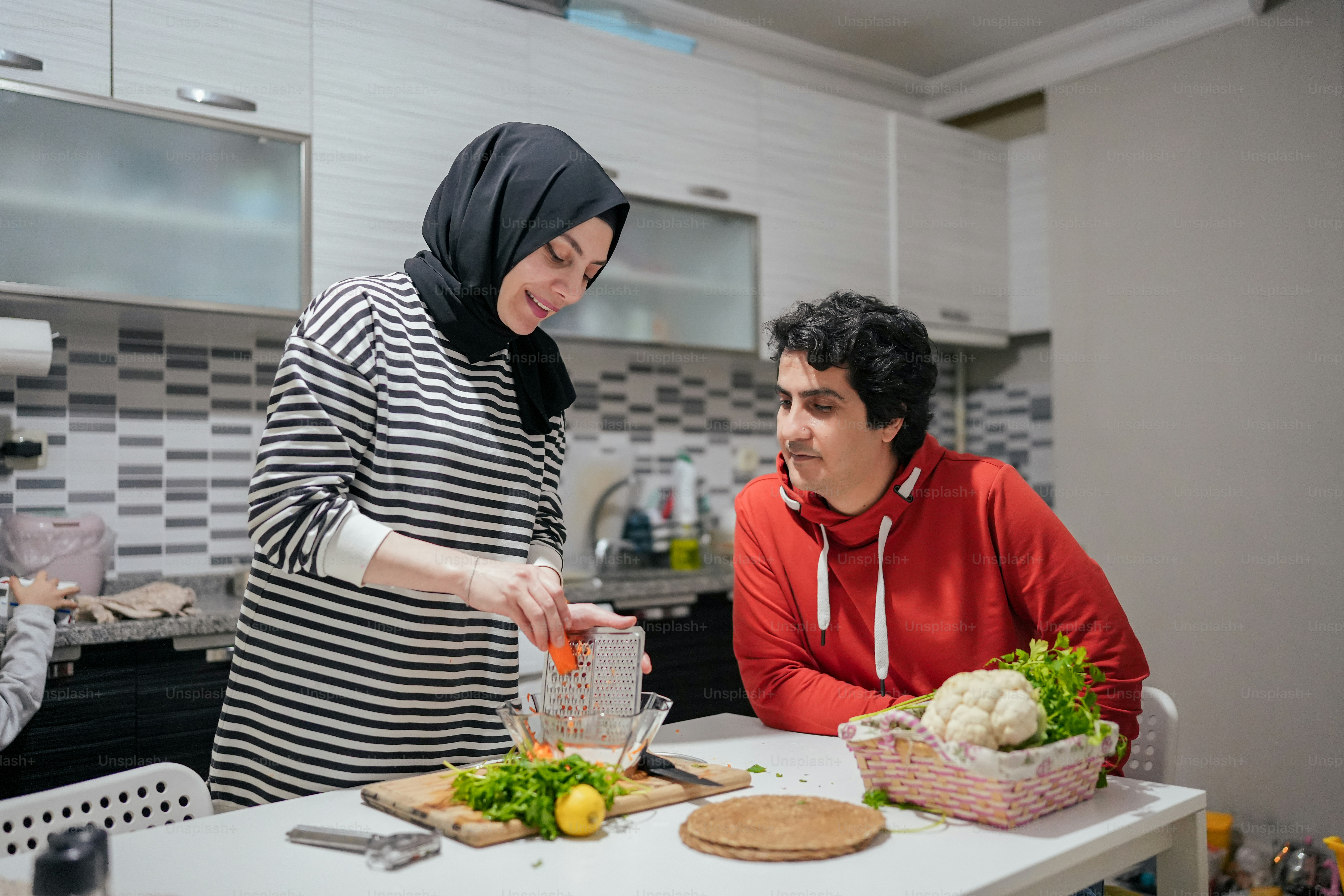 a man and a woman preparing food in a kitchen