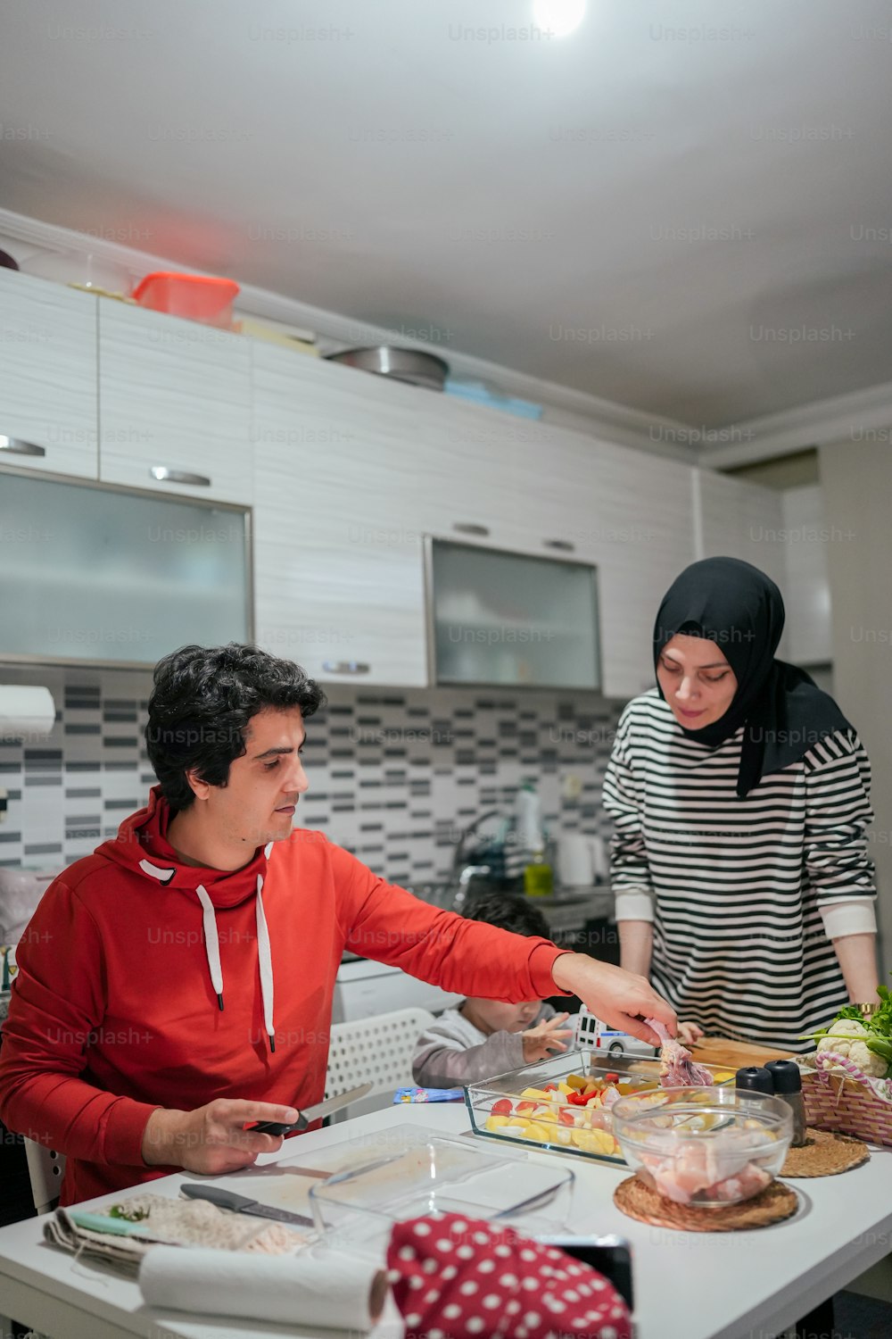 a man and a woman preparing food in a kitchen