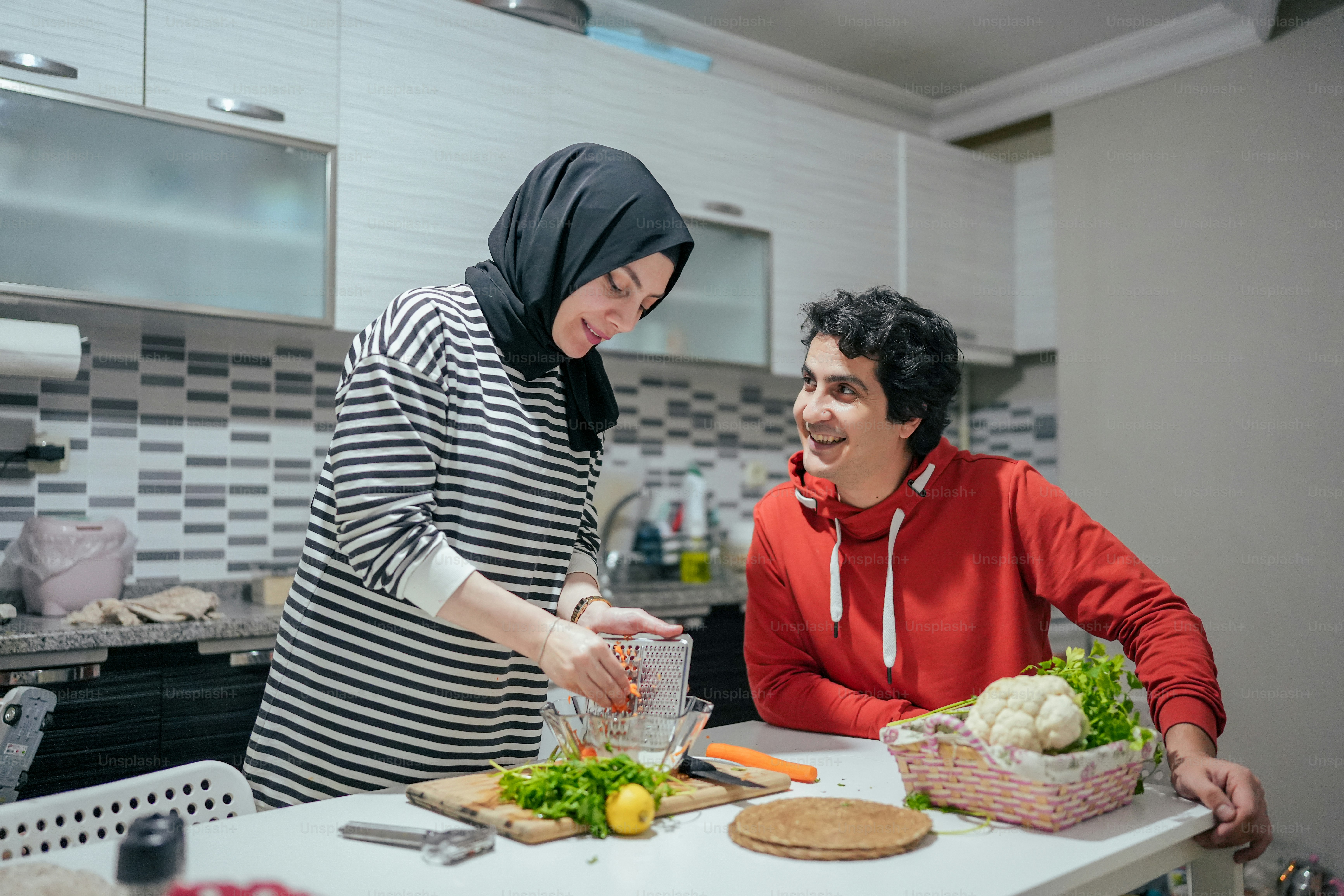 a man and a woman preparing food in a kitchen
