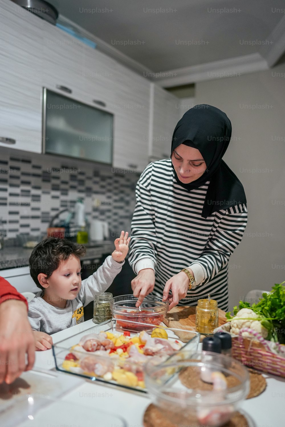 台所で食事を準備する女性と2人の子供