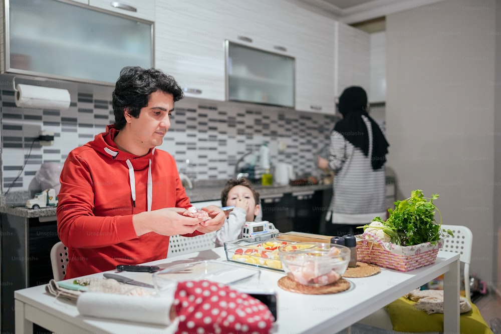 a man sitting at a table in a kitchen