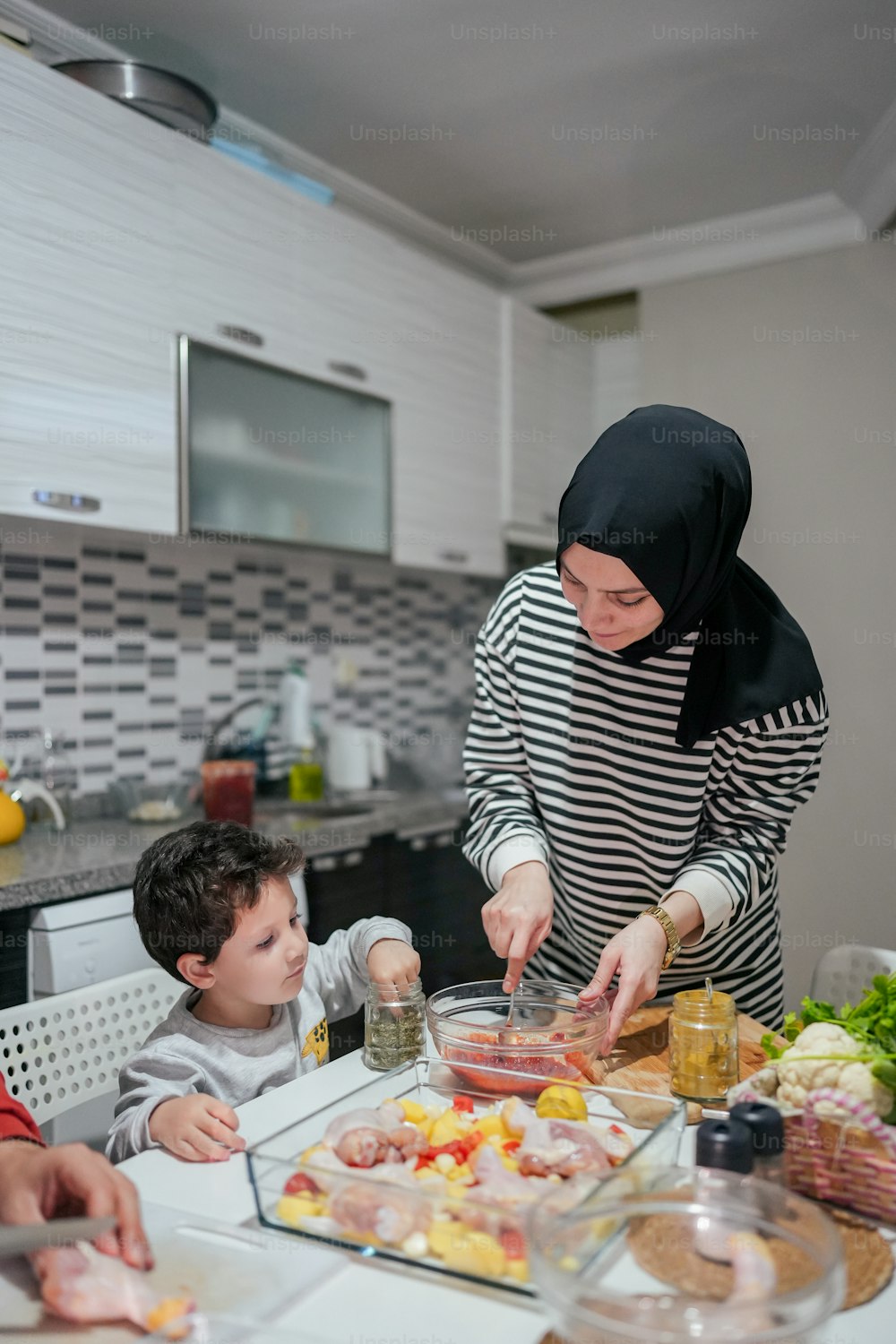 uma mulher e duas crianças preparando comida em uma cozinha