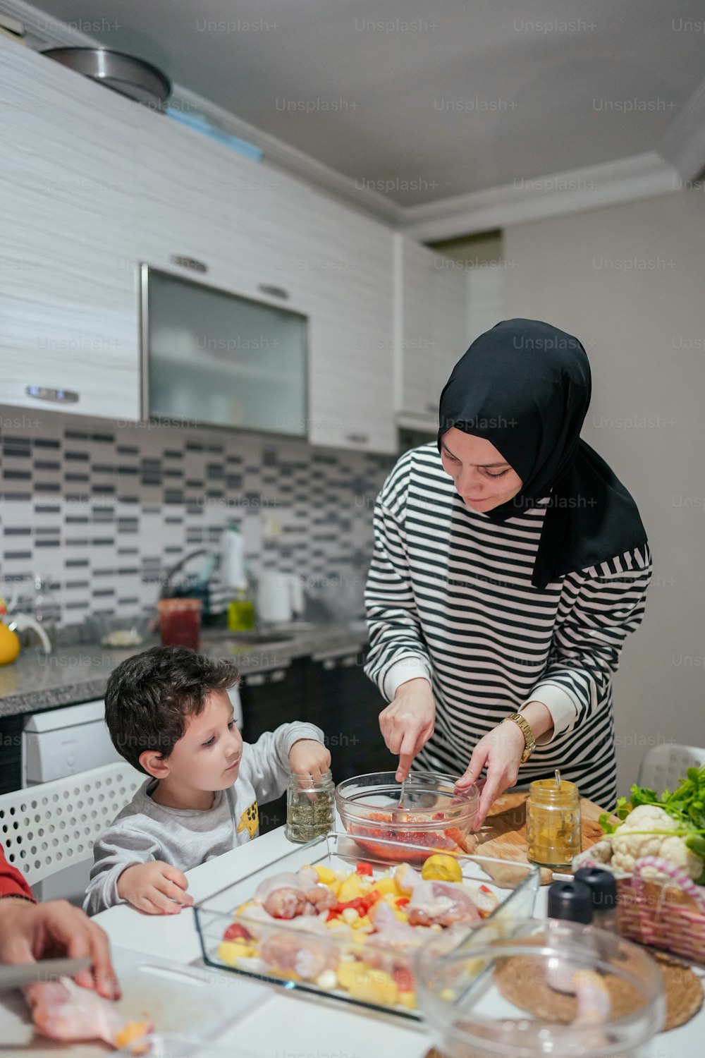 a woman and two children preparing food in a kitchen