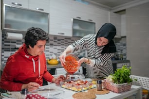 a man and a woman preparing food in a kitchen
