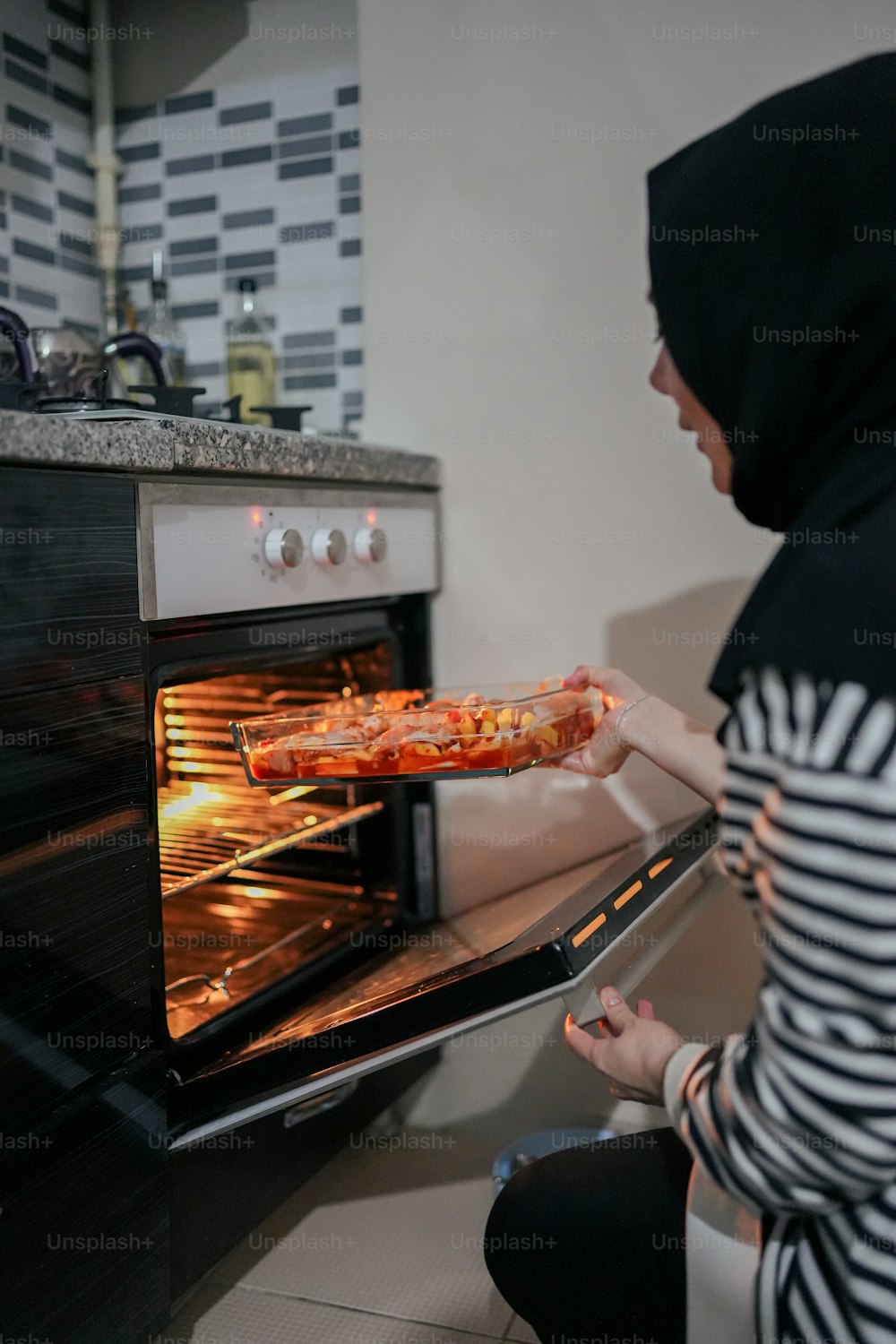 Una donna sta tirando fuori una pizza dal forno