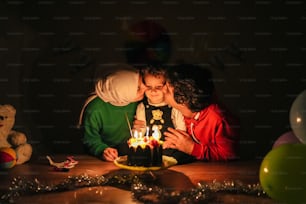 Un uomo e una donna che si baciano davanti a una torta di compleanno