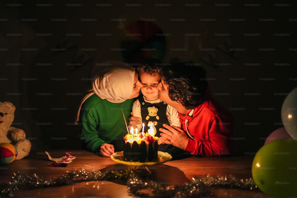 a man and woman kissing in front of a birthday cake