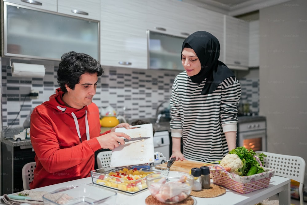 um homem e uma mulher preparando comida em uma cozinha