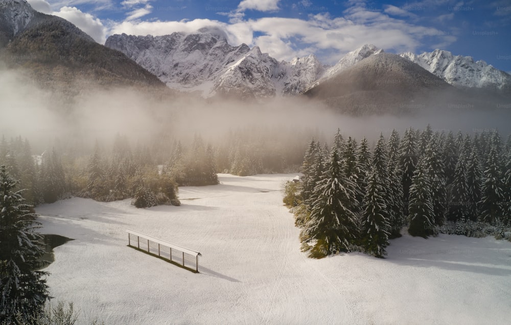 a snow covered field with a fence in the foreground