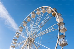 uma grande roda gigante sentada sob um céu azul
