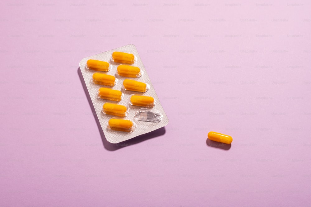 un paquet de pilules assis sur une surface violette