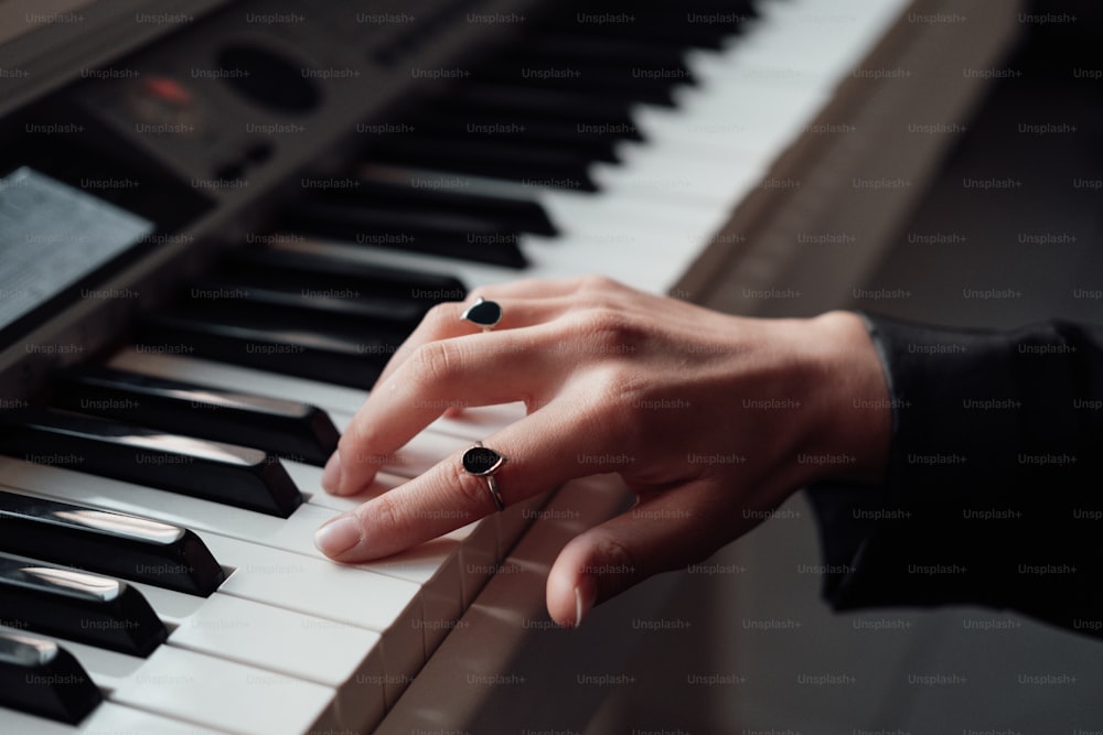 a person's hand resting on a piano keyboard