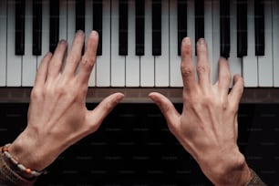 a person's hands reaching for a piano keyboard