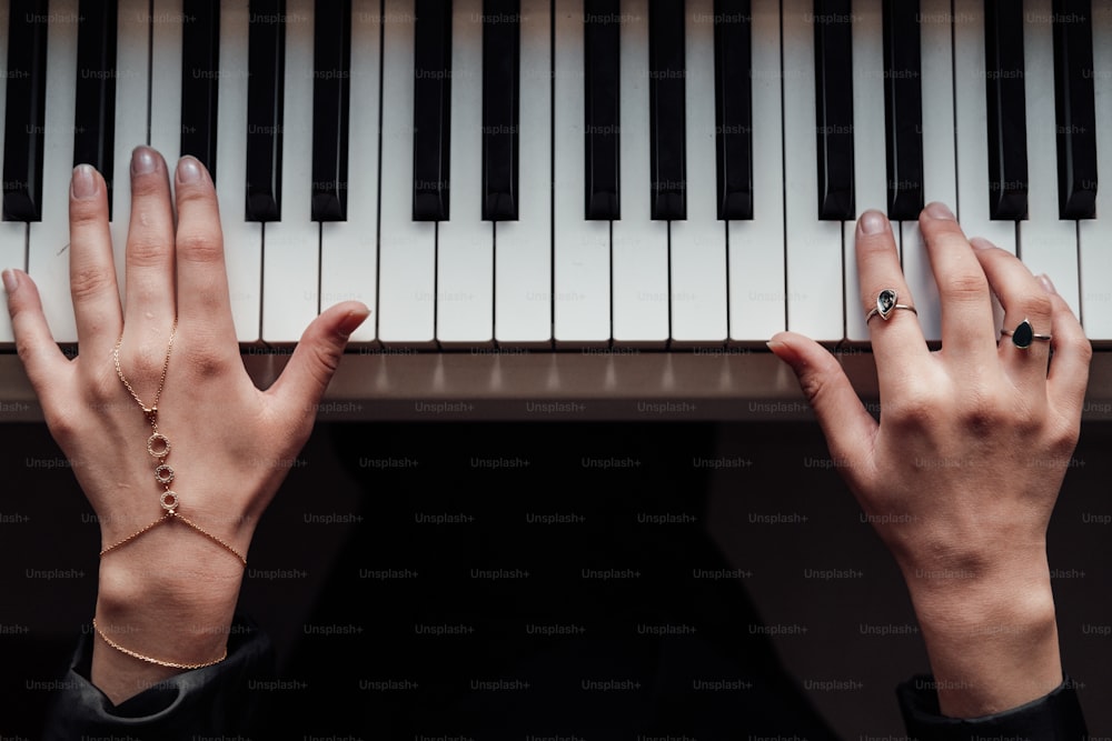 a person with their hands on a piano