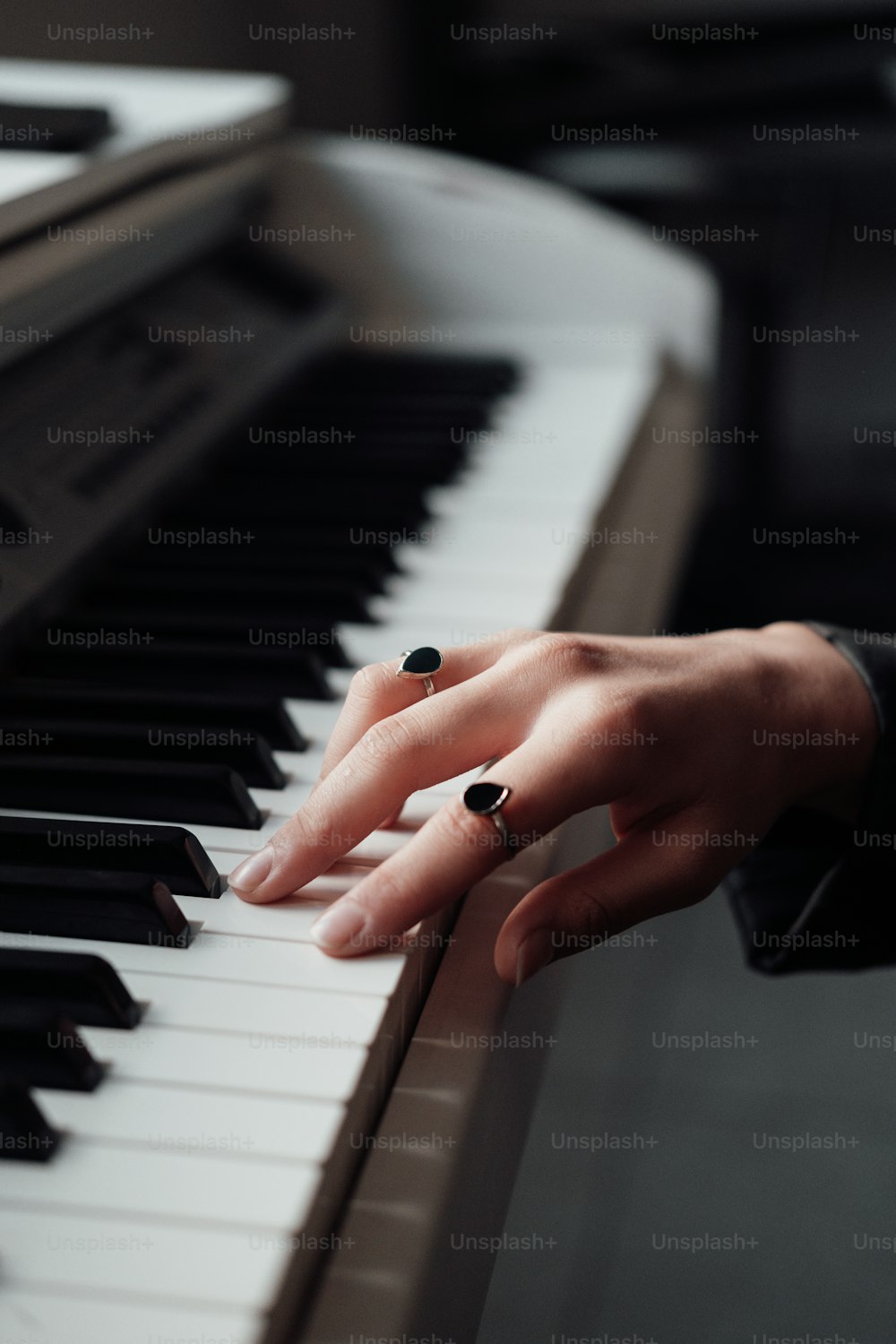 a woman's hand resting on a piano keyboard