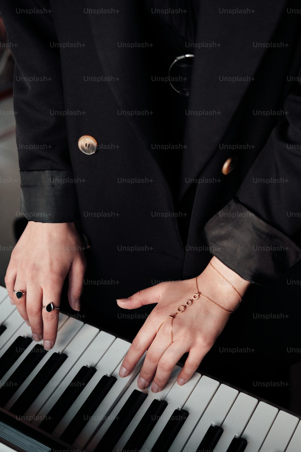 검은 양복을 입은 사람이 피아노를 연주하고 있다