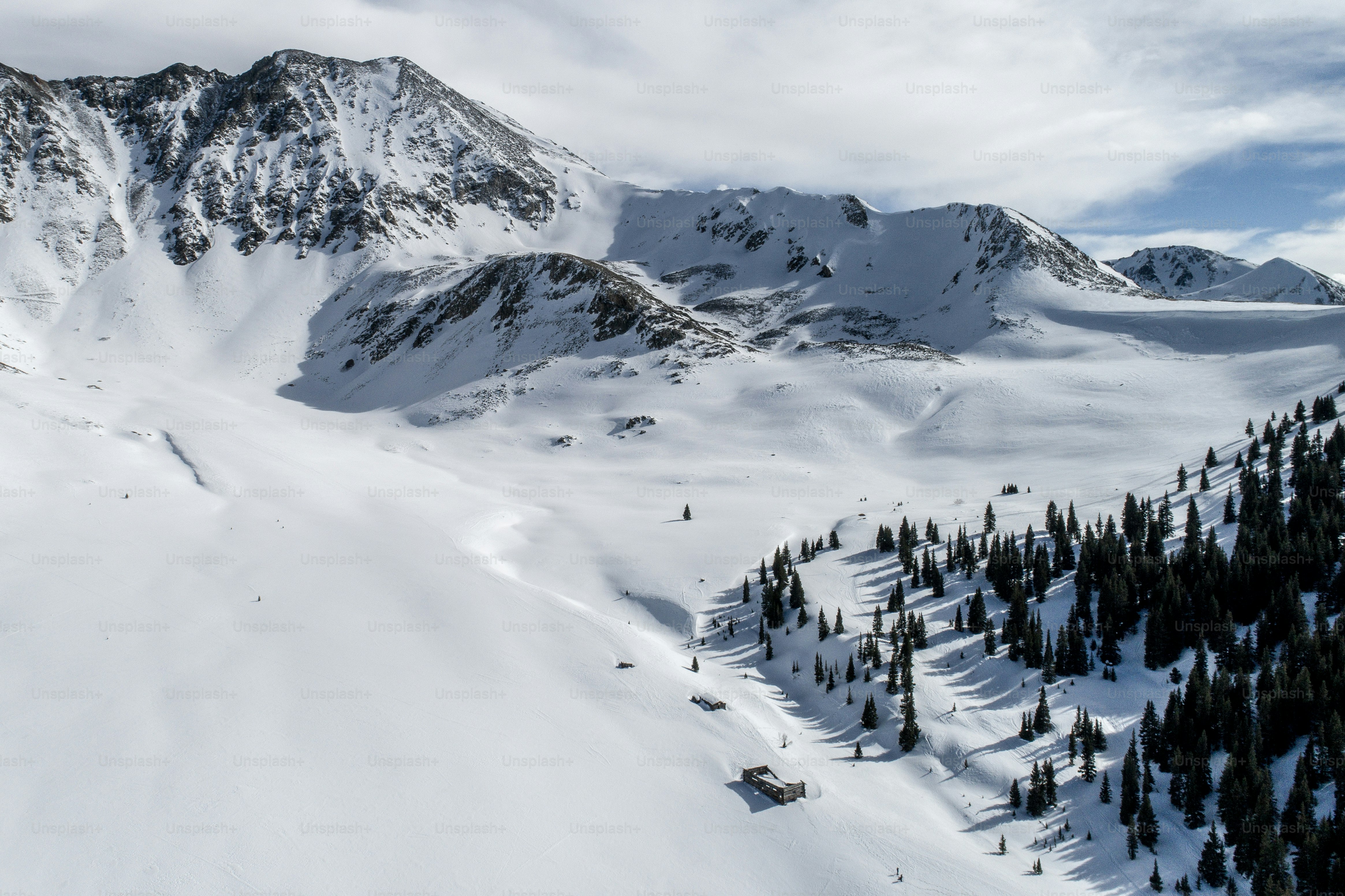 gunung yang tertutup salju dengan lift ski di kejauhan