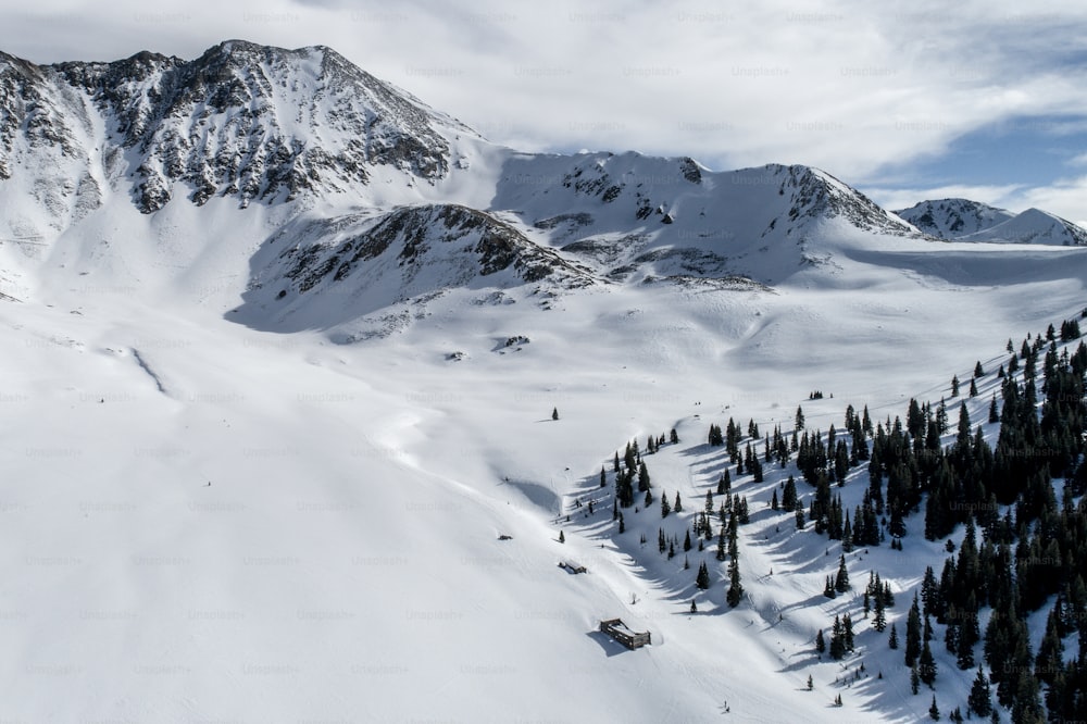 ein schneebedeckter Berg mit einem Skilift in der Ferne
