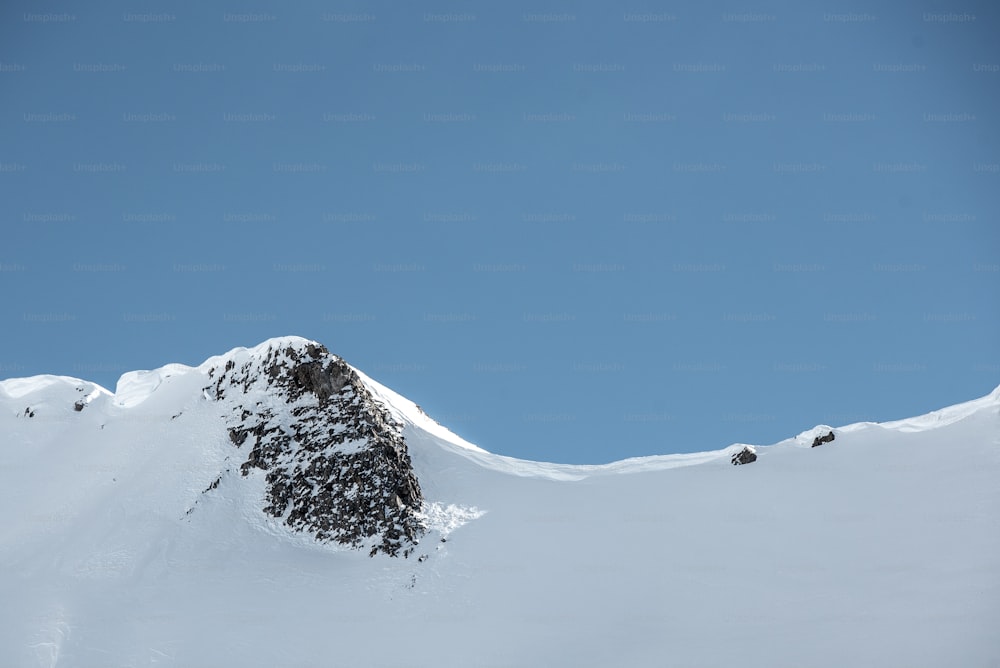 um snowboarder está pulando de uma montanha nevada