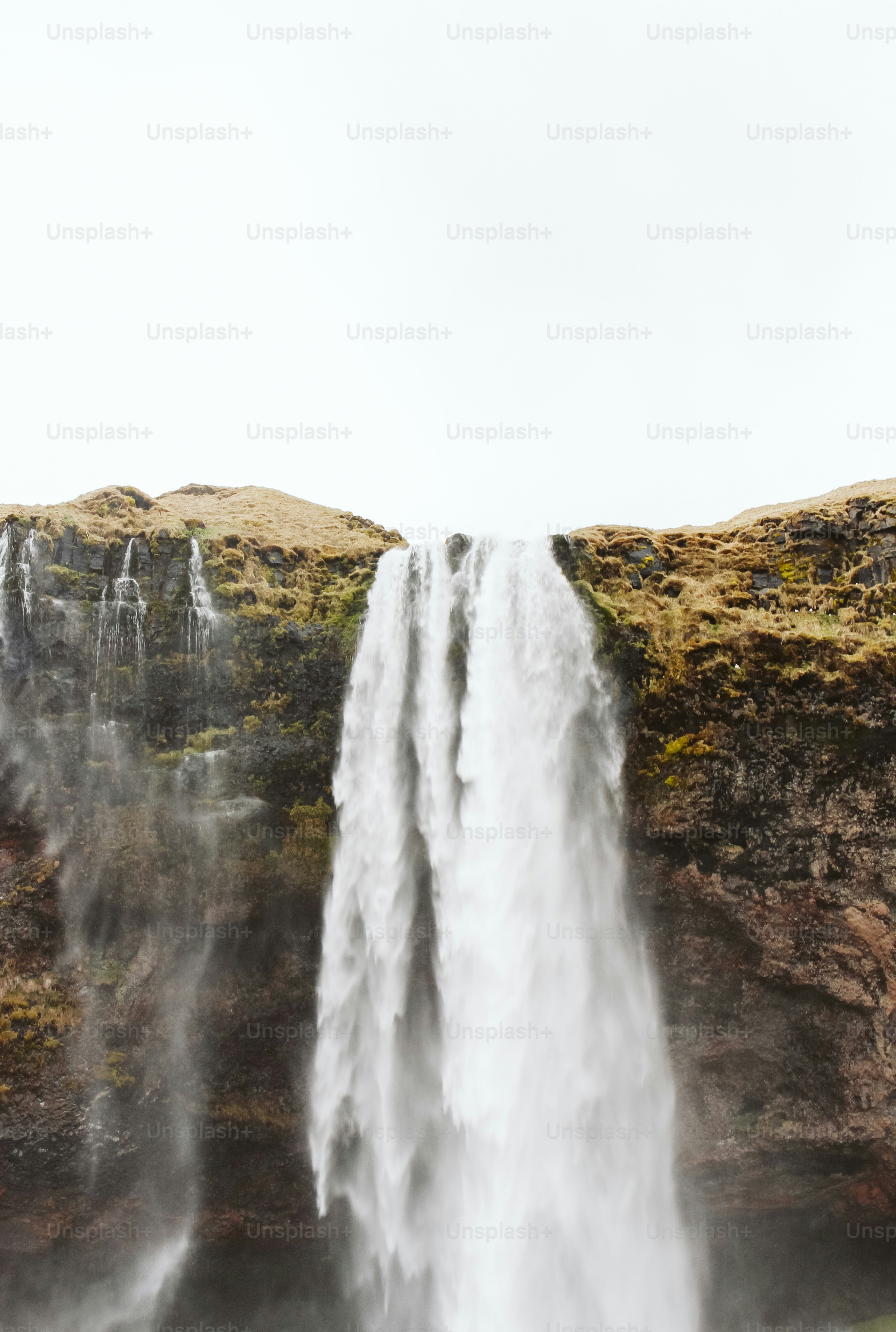 una grande cascata con un uomo in piedi di fronte ad essa