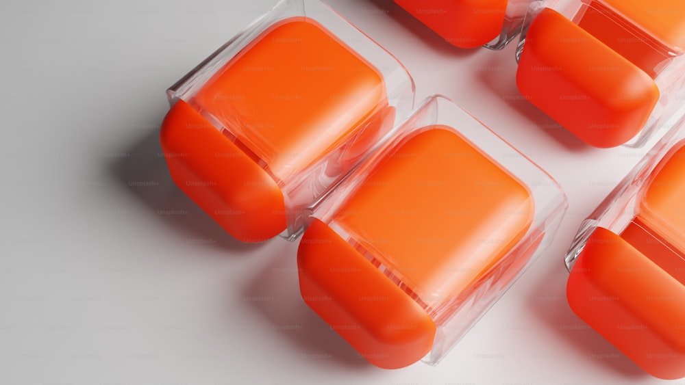 Un grupo de recipientes de plástico naranja sentados encima de una mesa