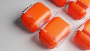 Un gruppo di contenitori di plastica arancione seduti sopra un tavolo