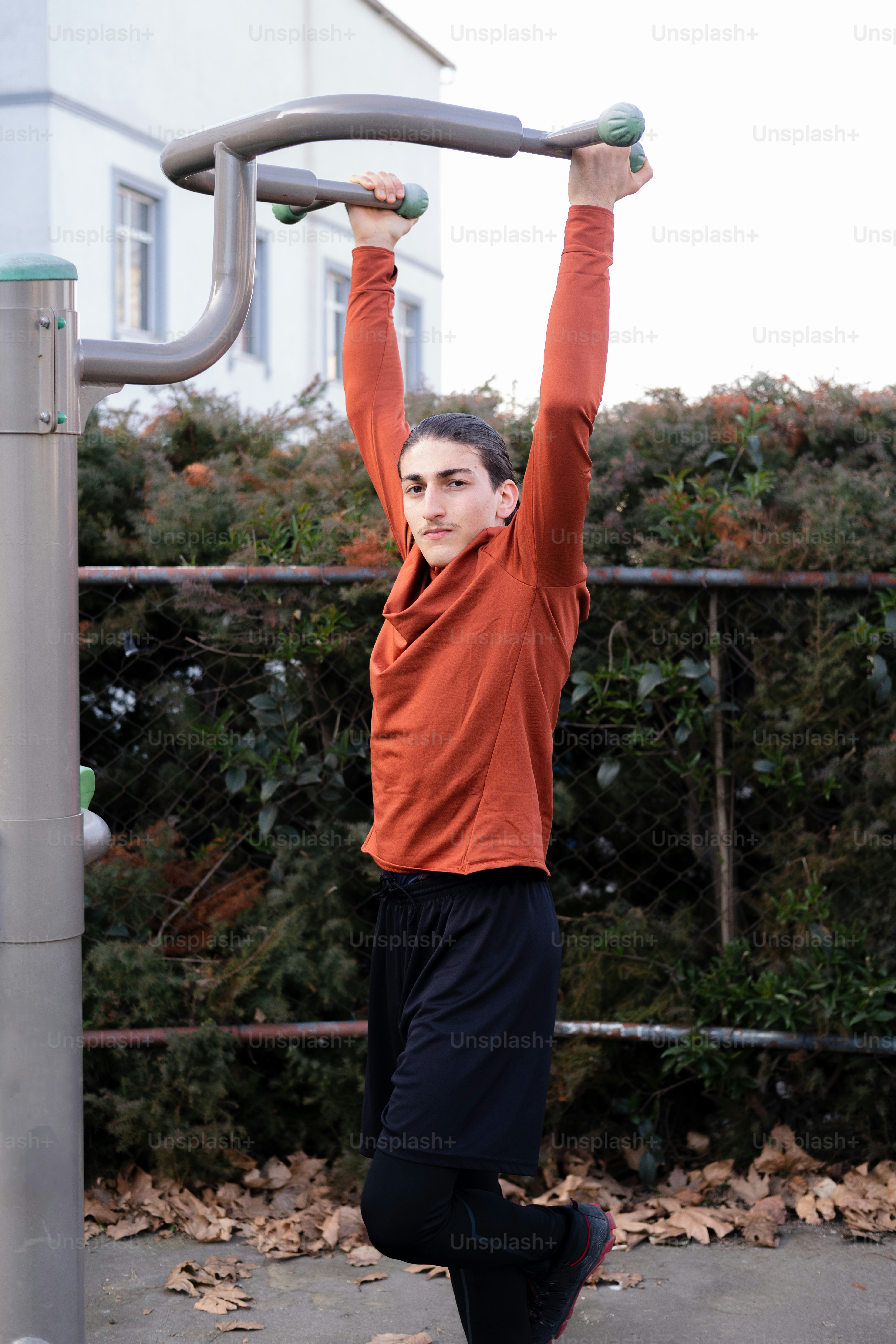 a young man doing a pull up on a metal bar