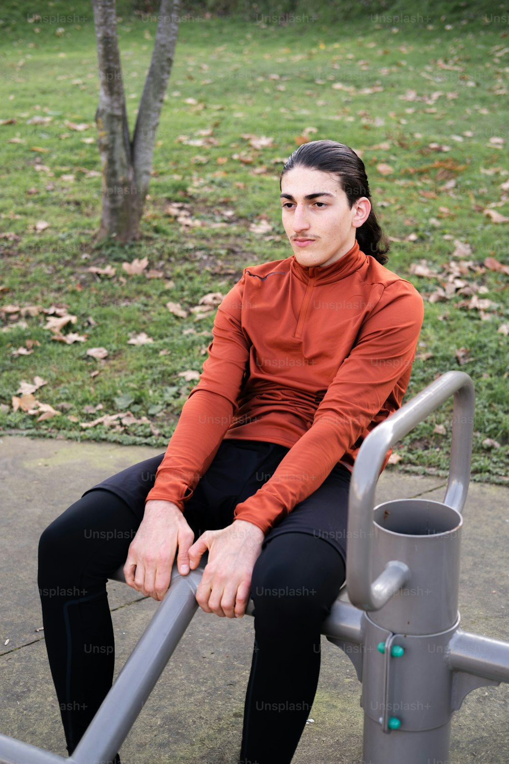 a woman sitting on top of a metal bench
