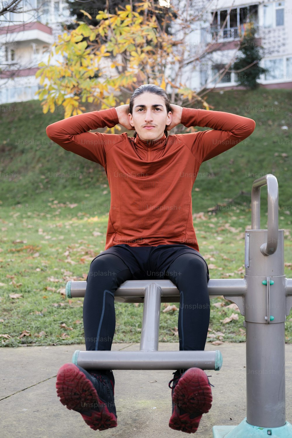 a woman sitting on top of a metal bench
