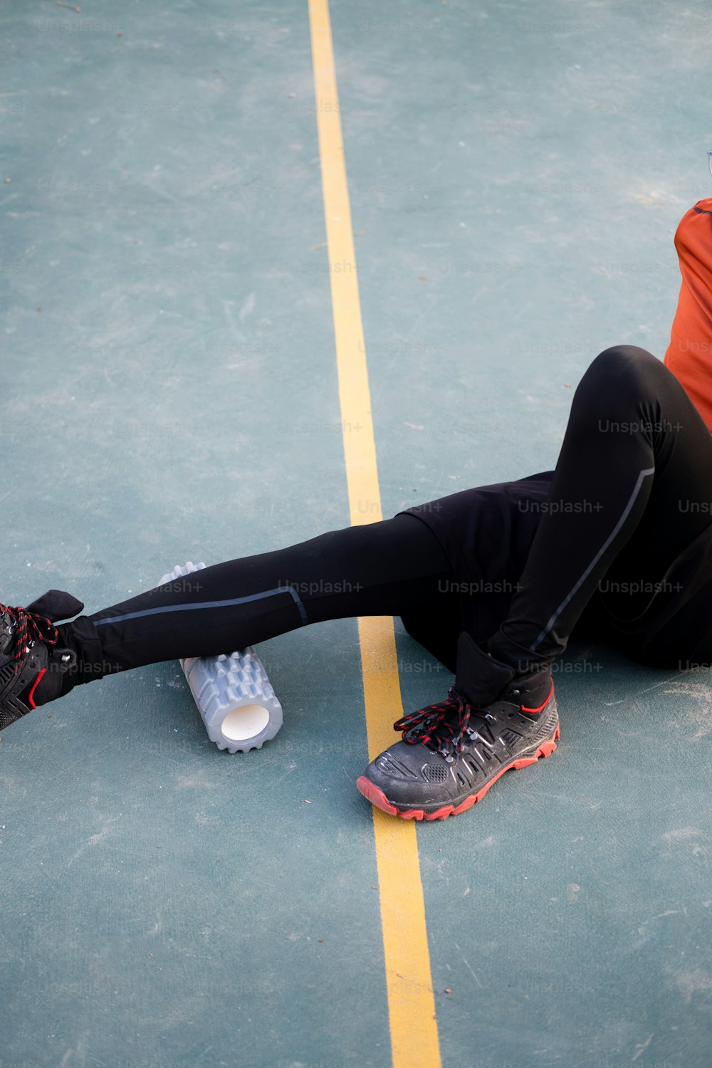 une personne assise sur un court de tennis avec les pieds sur terre