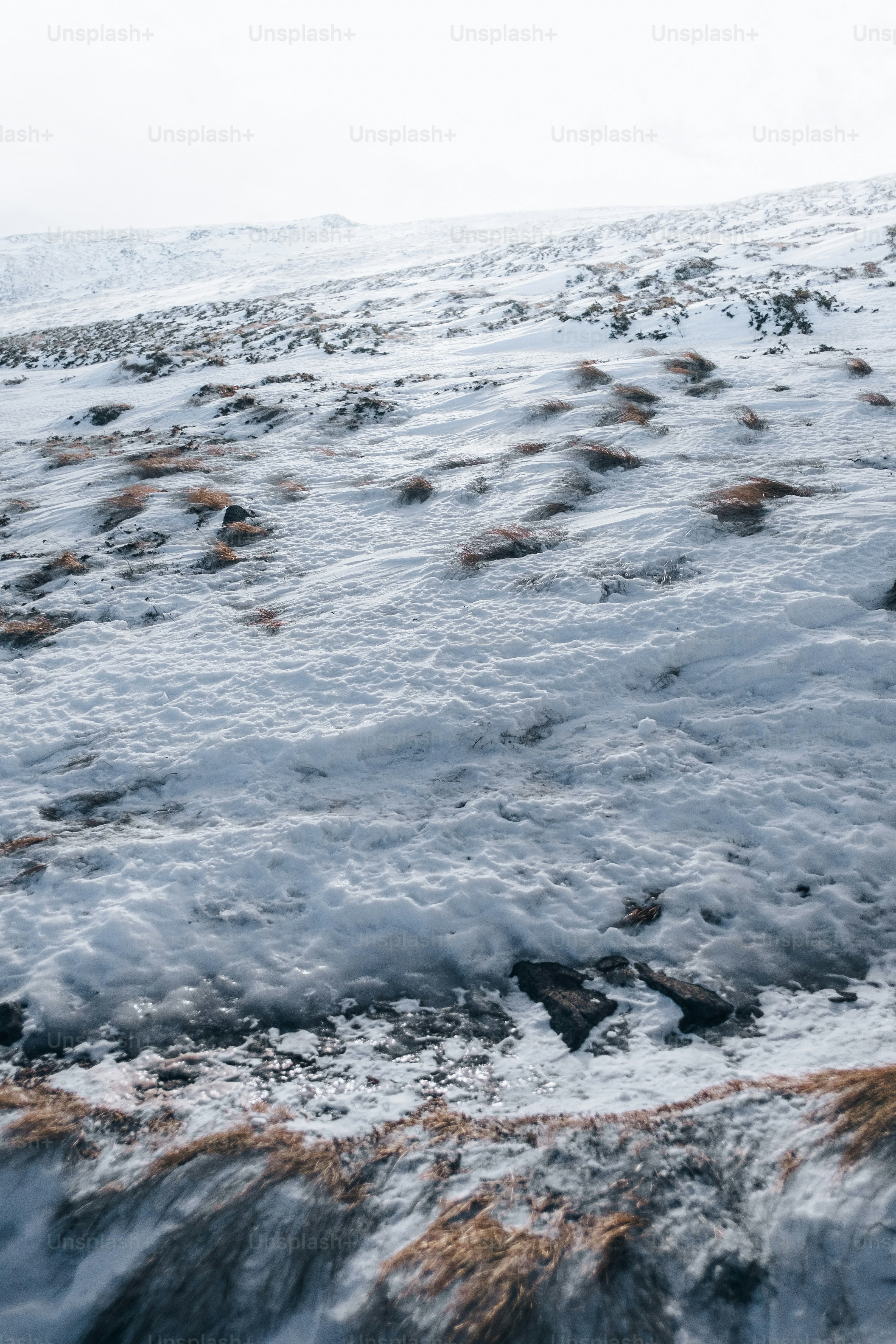 a snow covered hill with a snowboard on top of it