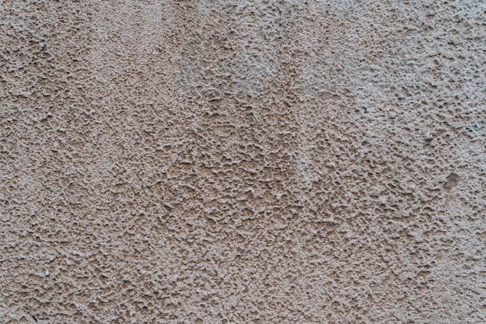 a close up of a cement wall with small holes in it