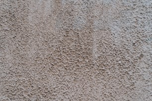 un primer plano de una pared de cemento con pequeños agujeros